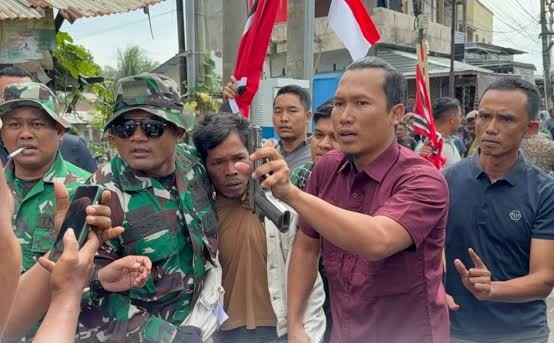 Aparat mengamankan seorang pria yang diduga kuat membawa senjata api. *Foto:AG